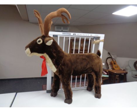 A metal baby gate together with a large reindeer soft toy.