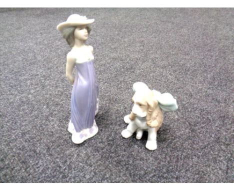 A Nao figure of a puppy together with a Lladro figure of a lady in a purple dress. 