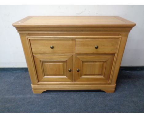 A contemporary light oak side cabinet fitted with two drawers. 