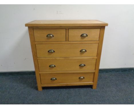 A contemporary light oak five drawer chest. 
