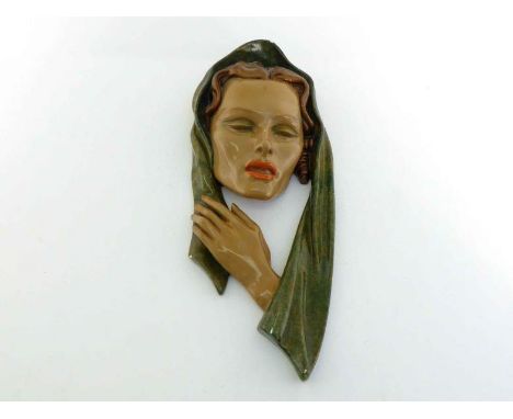After Goldscheider. A plaster wall plaque of a  lady's mask with head shawl in the manner of Goldscheider with painted and la