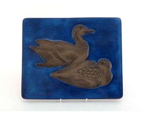 A Danish ceramic wall plaque of two ducks, part matt glazed, swimming on a blue glazed pond. Beehive mark of the Aluminia wor