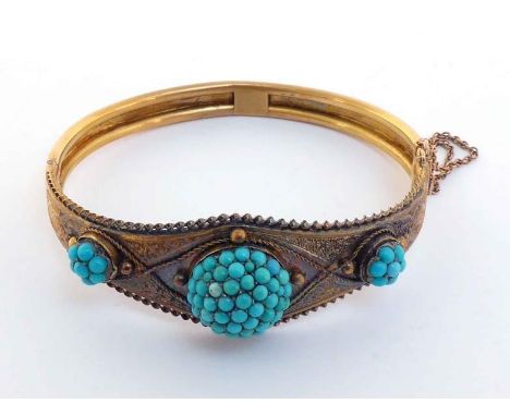 A Victorian gold and turquoise-set hinged bangle, circa 1870, set to the front with three graduated domed turquoise cabochon 