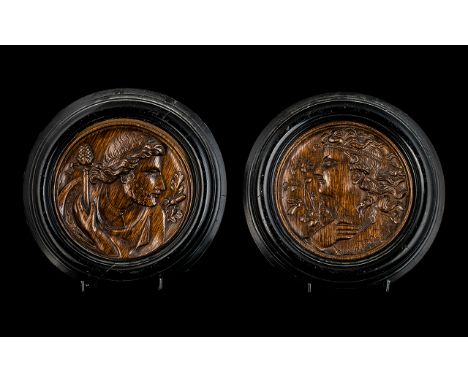 Pair of Fine Quality Antique Carved Oak Roundels in ebonised frames, one showing the portrait of an archaic man with flowing 
