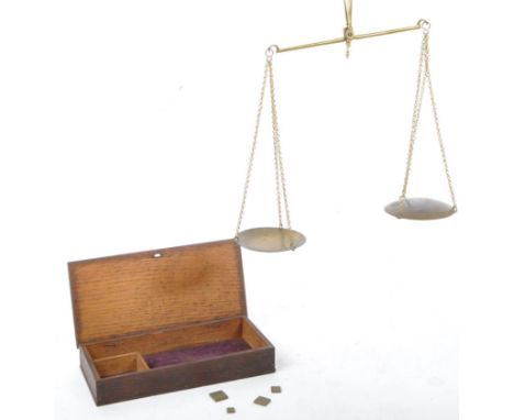 A set of early 20th century boxed apothecary scales accompanied by weights marked up in Arabic. Measures 18cm length.&nbsp;