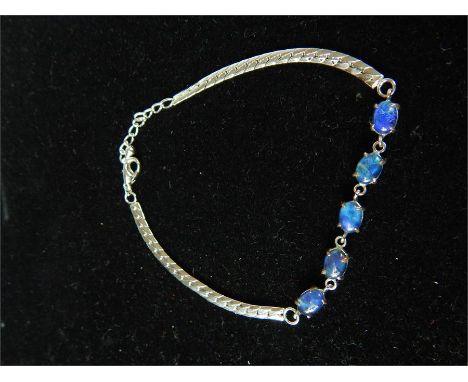 A boxed, sterling silver and Australian opal (doublet) bracelet composed of a silver curb chain, centrally set with five, cla