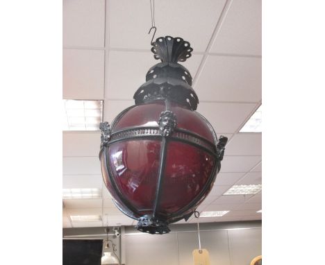 A large red glass globe and black painted hanging lantern  