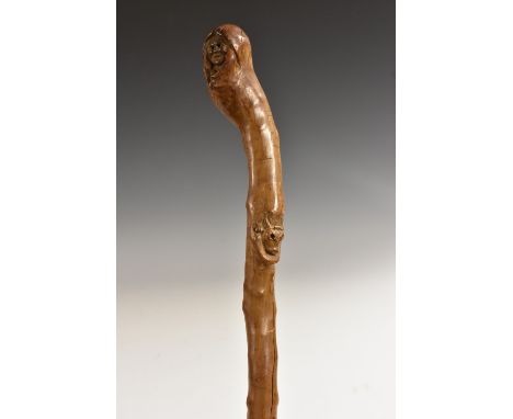 A 19th century folk art walking stick, carved with a face and the head of a bull, 93cm long