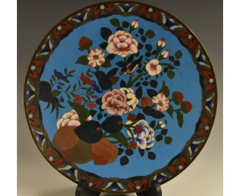 An Oriental cloisonné enamel circular charger, decorated in polychrome with a profusion of flowers, a songbird amongst the br