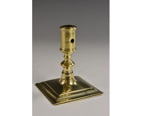 A Queen Anne brass candlestick, of squat proportions, heemskerk type socket sconze, knopped stem, square base, 10.5cm high, c