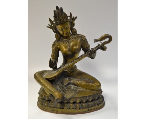 Indian School, a brass deity playing a lute, oval base, 32 high