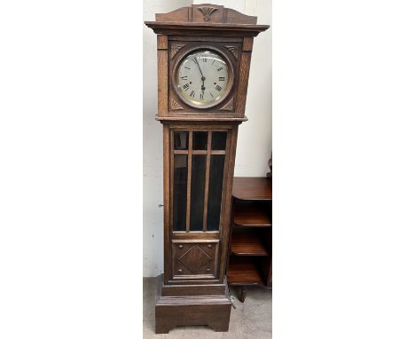 An oak cased grandmother clock, with a silvered dial and glazed door on bracket feet