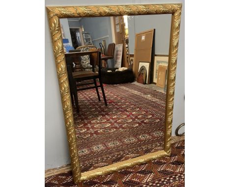 A gilt framed wall mirror decorated with leaves 