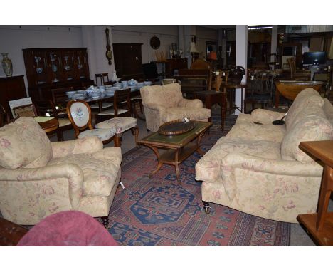 A three-piece drawing room suite, upholstered by George Smith, to include: sofa and two armchairs, raised on turned legs with