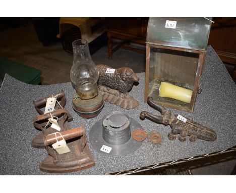 *19th Century metalware, to include: an oil lamp; a candle box; three irons; an inkwell; a door stopper in the form of a shee