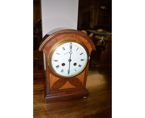 An Edwardian inlaid mahogany mantel clock, by Hamilton, the white enamel roman dial in fitted case with oyster veneered arche