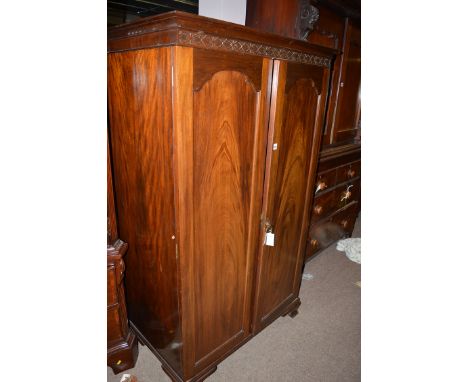A mahogany side cabinet, the arched panelled doors raised on bracket feet.