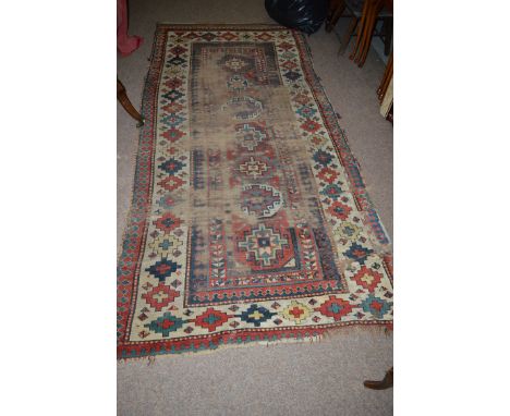 *An early 20th Century Caucasian short runner, decorated with bold geometric forms (very worn, holes in the middle, patch to 