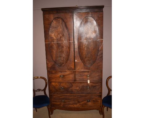 *A Regency period mahogany converted linen press, the associated cornice above a pair of oval panel doors enclosing hanging s