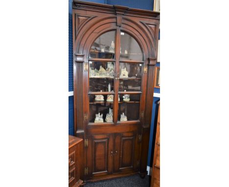 A 19th century oak Country House floor standing corner vitrine/display cabinet, moulded cresting above a pair of glazed doors