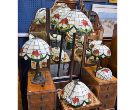 A Tiffany style standard lamp with leaded shade, two similar graduated table lamps, three wall pockets and a ceiling shade (7