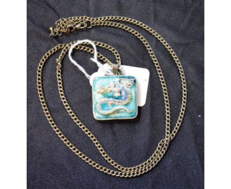 A Karlsrohe Pottery dragon pendant, on 36" white metal guard chain