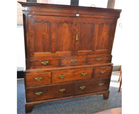 A George III oak press-on-chest, outswept cornice above a pair of panel doors and three short blind drawers enclosing a shelf