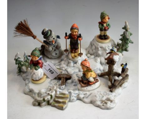 A Hummel Goebel Christmas advertising window display stand and figures, including Snowman, Skier, Tobogganist, It's Cold, Fir
