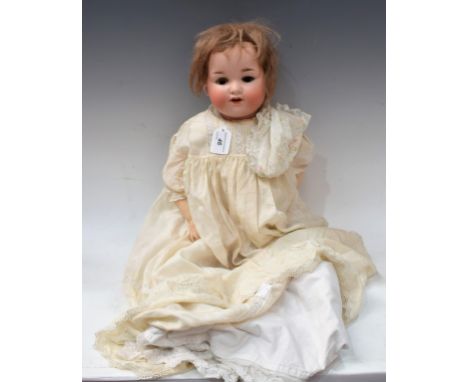 An Armand Marseille 990 socket head doll, sleeping brown eyes, open mouth with two teeth, short light brown wig, impressed Ar