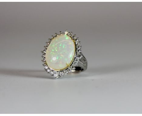 An 18ct white gold ring set with a large opal (Approx 10.1 carat) surrounded by brilliant cut diamonds. (O) Est. £1000 - 1500