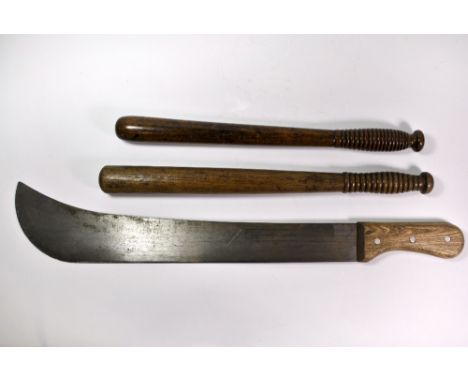 Two early wooden truncheons and a machete.