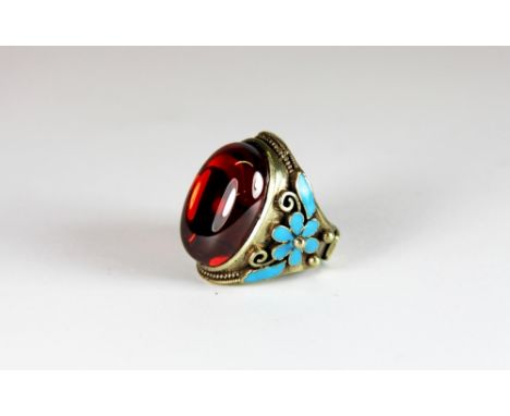 A Chinese signed enamelled white metal ring set with a large realgar ("ruby stone"). Adjustable size from R