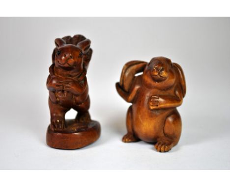 A signed and carved fruitwood netsuke of a rabbit and a further fruitwood figure of a rabbit carrying a basket.