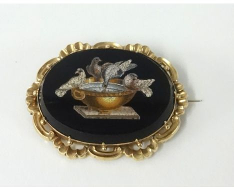 An antique gold and micro mosaic brooch depicting birds on a bird bath.