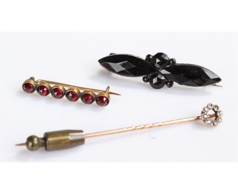 Victorian yellow metal and diamond set stick pin, the circular head set with diamonds, together with garnet set brooch, and a