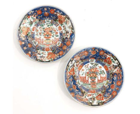 Kangxi Period, decorated with jardiniere of peonies, chrysanthemums, pine and florals, 23 cm. in diameter, both restored. 