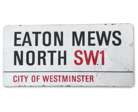An enamelled iron street sign for Eaton Mews North SW1, City of Westminster with iconic black and red sans serif lettering fi