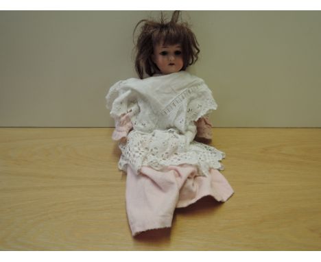An early 20th century Armand Marseille bisque headed Doll having jointed body, marked A1M 390, length 40cm, dressed in tradit