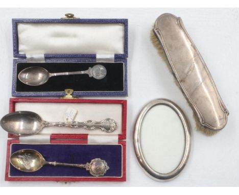 Two boxed QEII silver teaspoons, a further silver teaspoon (combined 62g), with a silver backed brush and an oval photography
