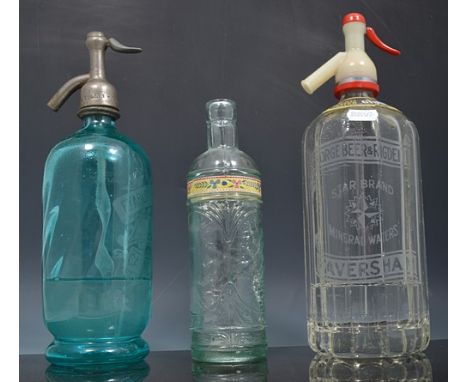 Two soda water bottles, other vintage bottles and a stoneware jar.