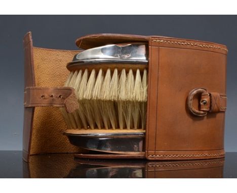 Pair of Edwardian silver backed clothes brushes, Chester 1906, embossed ribbon decoration, 14cm and a comb in a leather case.