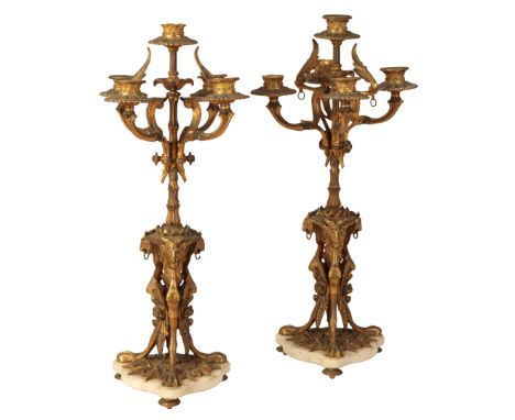 A PAIR OF REGENCY STYLE GILT METAL FIVE LIGHT CANDELABRA each branch with petal moulded sconce, on columnar stem to triform b