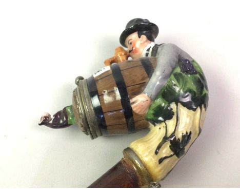 GERMAN CERAMIC NOVELTY SMOKING PIPE, modelled with a barrel and man with hat30cm long