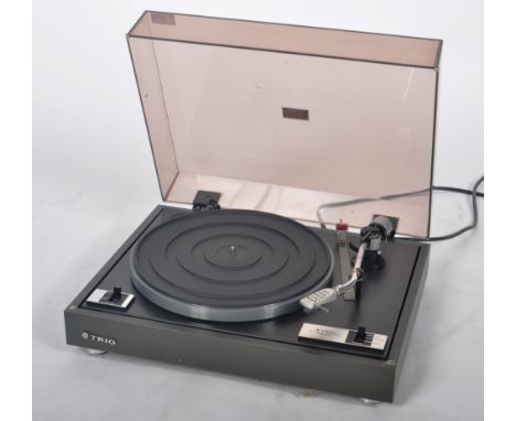 Trio - Model KD-1033B - A belt driven record player turntable deck having a smokie perspex hinged cover set to a metal base. 