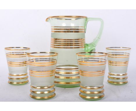 A retro vintage c. 1960'S matching glass water jug and drinking glasses. With a tint of green with gilt circular stripes. Mea