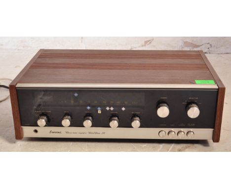 Sansui - Model 310 - A Solid State AM / FM Stereo Tuner Amplifier having a glass and polished metal front set with a teak woo