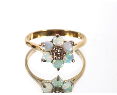 An 18ct gold opal and diamond floral cluster ring, ring size Q/R. The central diamond with six opal border. Approx. 3g
