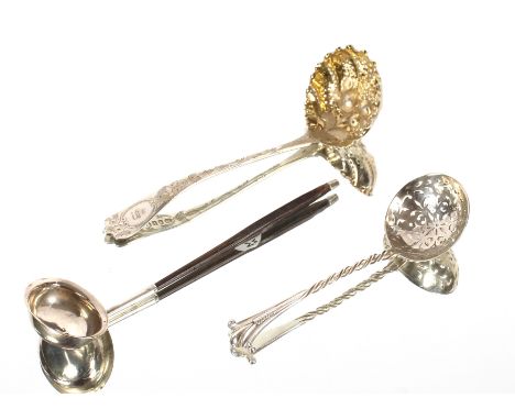 A George III silver sifter spoon, with foliate engraved decoration and monogram, the gilded bowl with raised fruit motif, a V