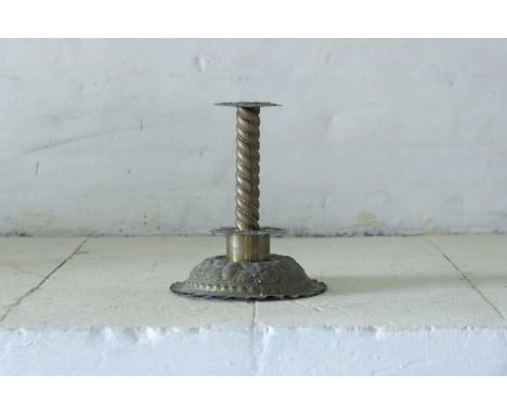 A 17th-century-style brass candlestick, 20th century, Dutch, with a pressed brass drip pan over a spiralled column and circul