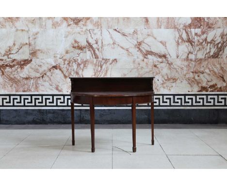 A mahogany demilune side table, late 19th century, with a gallery and a shelf, over a moulded edge, plain frieze and raised o